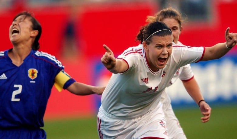 A woman soccer player celebrates a goal.