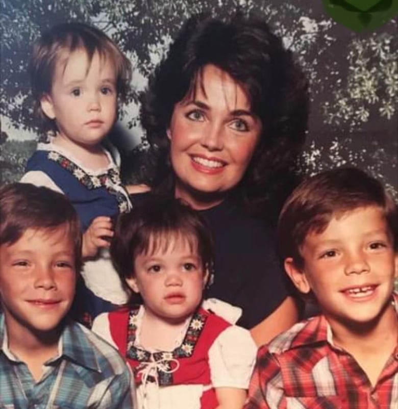 A family picture from the 1980s with a mom, two daughters and two sons.