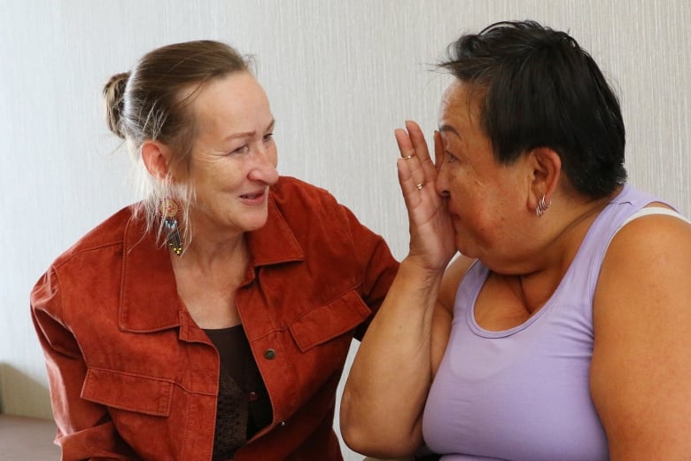 Yellowknife resident Yvonne Pokiak-Asher, right, is comforted by Northwest Territories Premier Caroline Cochrane during a media briefing in Calgary on Aug. 25.