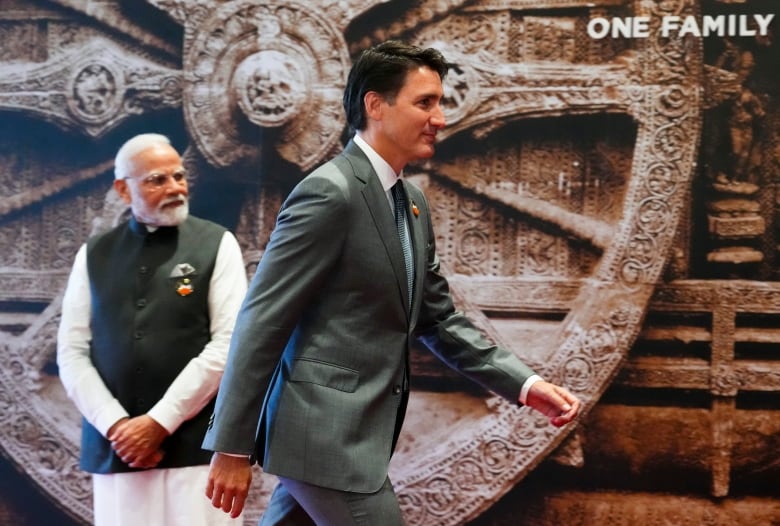 Canadian prime minister walks by India's prime minister.