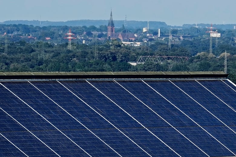 Solar panels in the foreground with a small town in the background