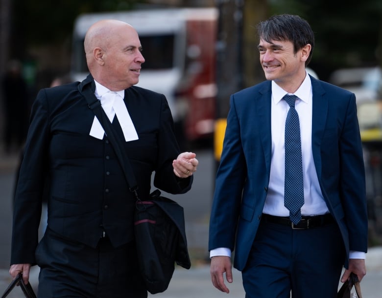 Cameron Jay Ortis, right, a former RCMP intelligence director accused of disclosing classified information, returns to the Ottawa Courthouse during a break in proceedings in Ottawa, on Tuesday, Oct. 3, 2023. 