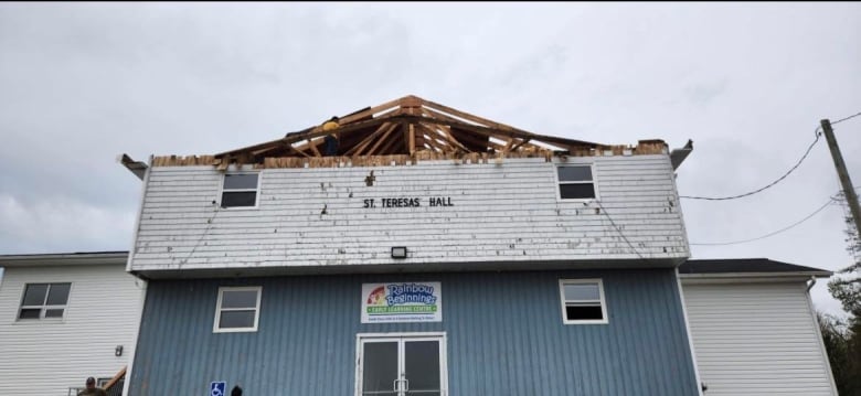 The frontside of St. Teresa's Hall is seen with the roof ripped off. 