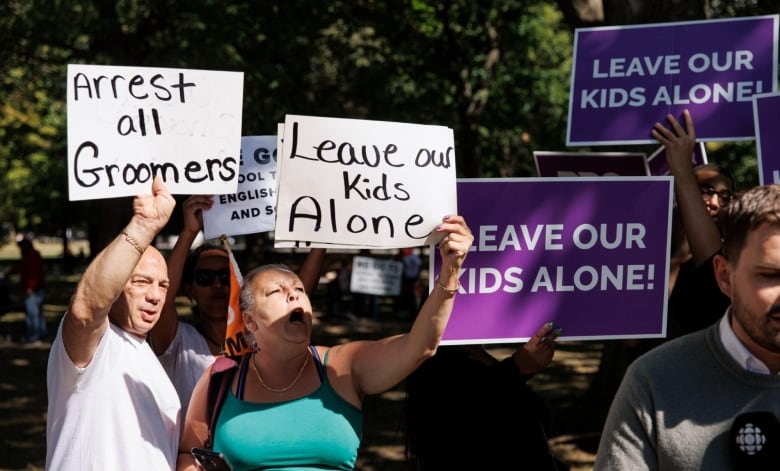 Protesters hold signs saying ‘Leave Our Kids Alone’ and ‘Arrest All Groomers.’