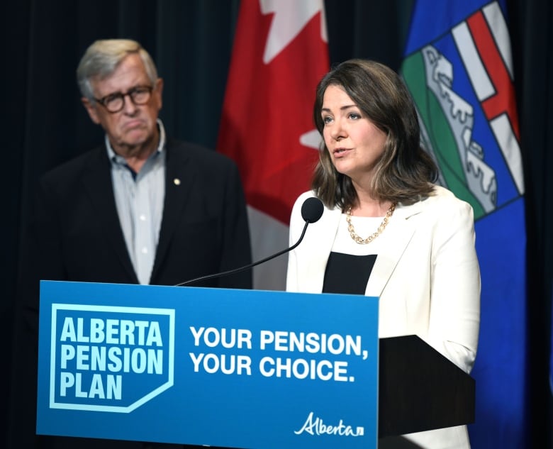 Jim Dinning watches as Premier Danielle Smith speaks at the Sept. 21 release of a report about an Alberta pension plan. Dinning, a former provincial finance minister, heads an engagement panel that will hold a series of telephone town halls across Alberta to gauge support for the proposed plan.
