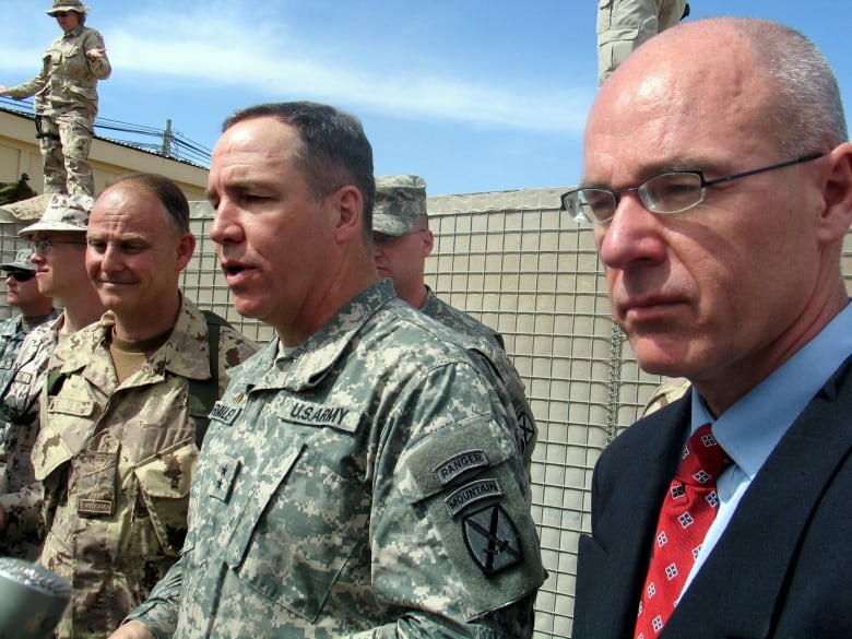 Canada's Special Representative to Afghanistan, David Sproule, stands to the right of CAF troops in his days as ambassador to Afghanistan. 