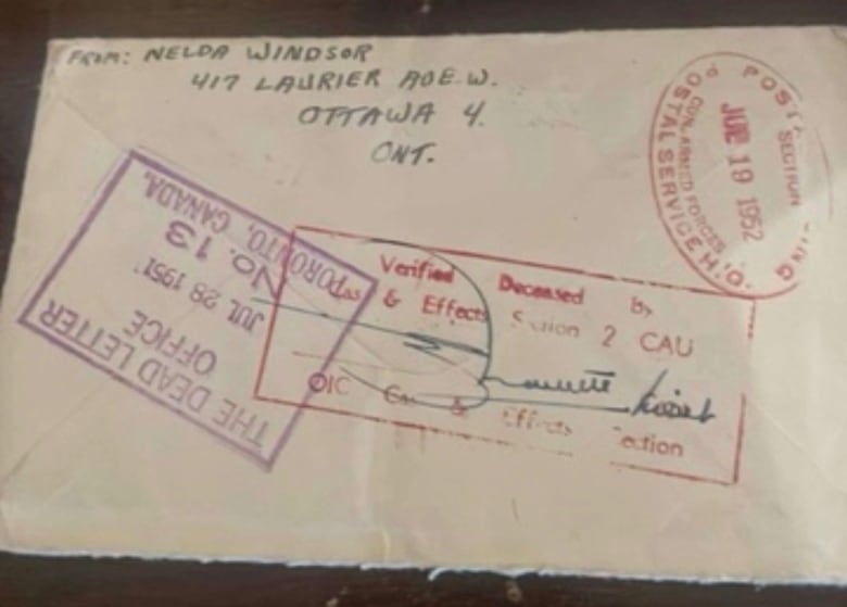 The back of a letter with stamps on it that say "dead letter office" and "verified deceased." 