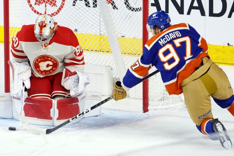 An NHL goalie stops a shot from hockey superstar Connor McDavid.