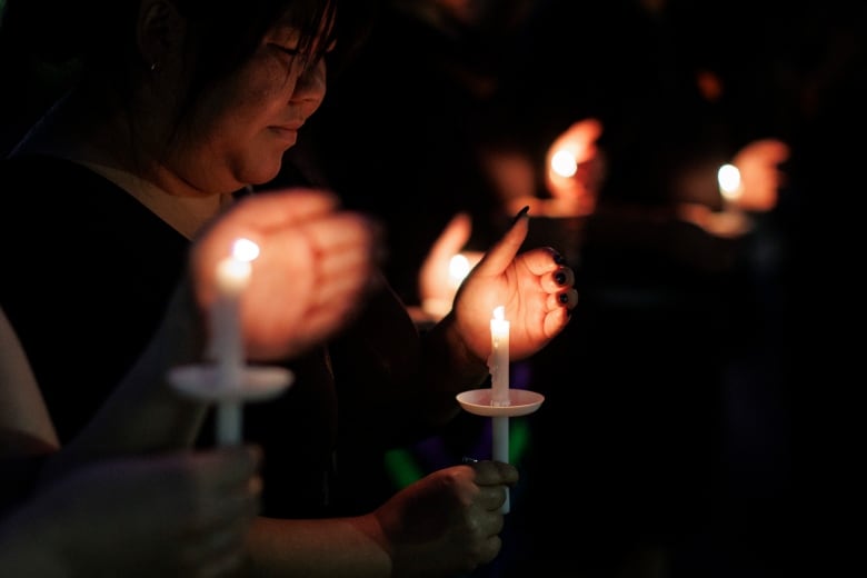 woman holding a candle at a vigil