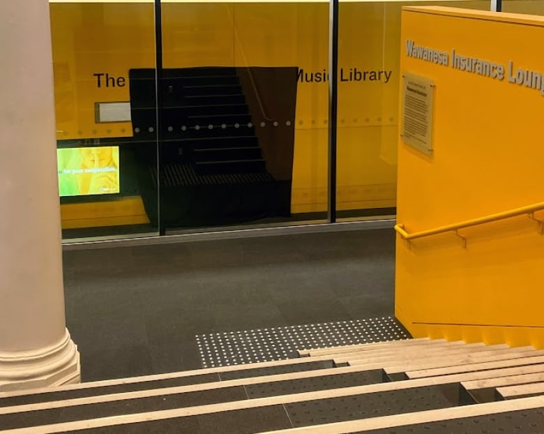 The glass entrance to a music library has part of the name covered with a black cloth.