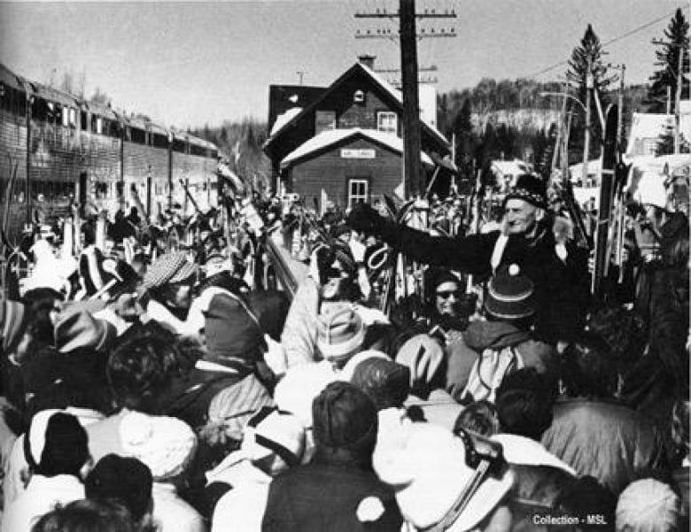 A man raises hands in a crowd during winter.