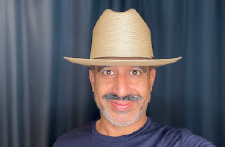 A man with a moustache wears a Stetson hat
