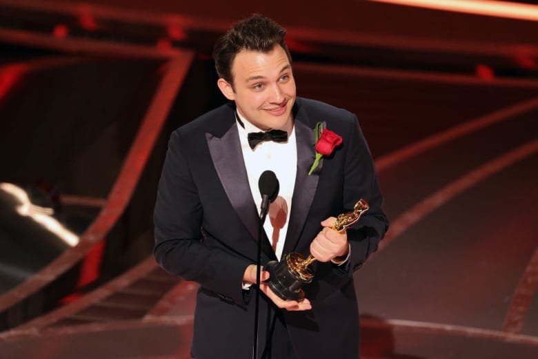 A man holds an Academy Award.