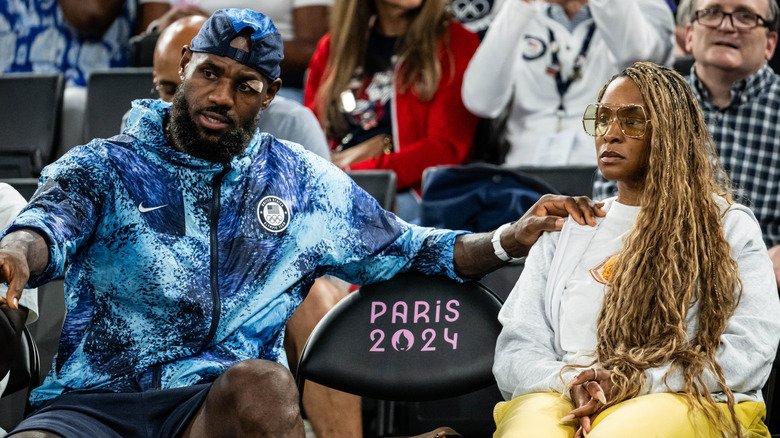 LeBron James holding Savannah James' shoulder at courtside