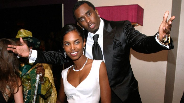 Kim Porter and Diddy pose together with playfulness.