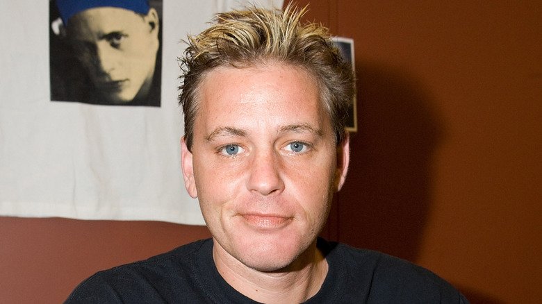 Corey Haim posing in front of a portrait