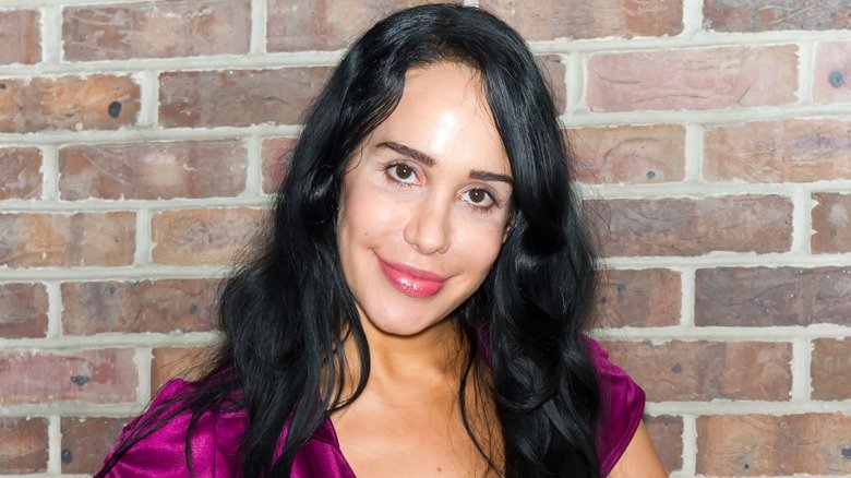 Natalie Suleman posing in front of a brick wall