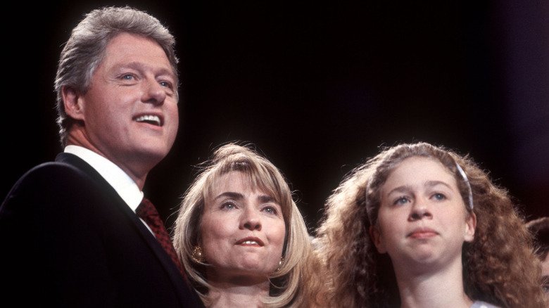 Ground-level photo of Bill, Hillary, and Chelsea Clinton looking ahead