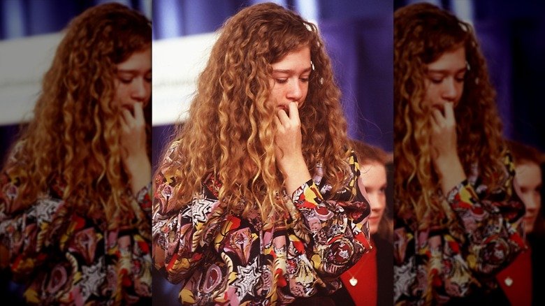 Teenage Chelsea Clinton looking down with her hand to her mouth