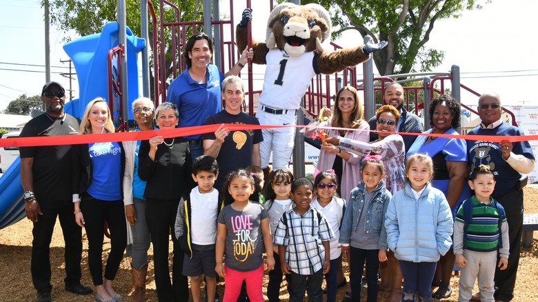 Carter Oosterhouse posing and smiling with a group of adults and children at Carter's Kids Playground Build and Ribbon-Cutting Ceremony