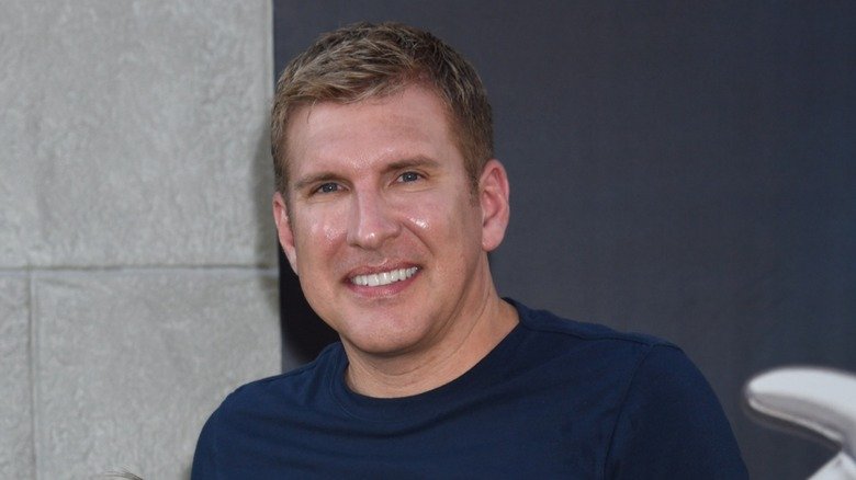 Dressed in a navy blue shirt, Todd Chrisley pastes a wide smile.