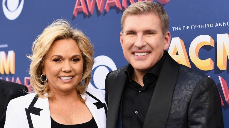 Dressed in black and white outfits, Todd and Julie Chrisley are all smiles.