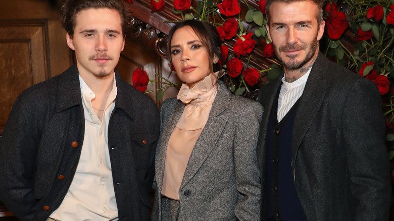 Brooklyn Beckham posing with parents Victoria Beckham and David Beckham