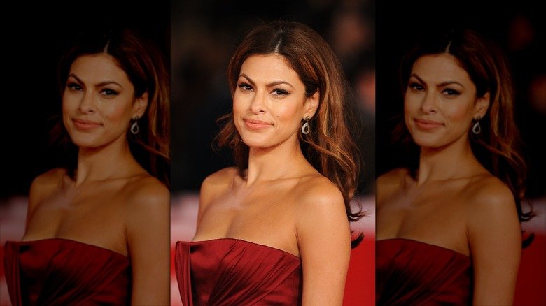 Eva Mendes posing on the red carpet in a strapless red dress