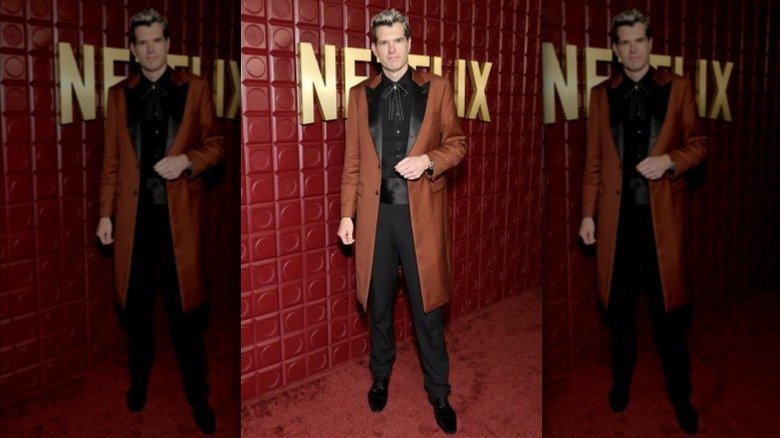 Timothy Simons wearing a brown coat, black shirt, and black pants