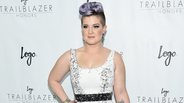 The More Candid Side of Kelly Osbourne 130 Kelly Osbourne with a purple pompadour wearing a black belted floral dress