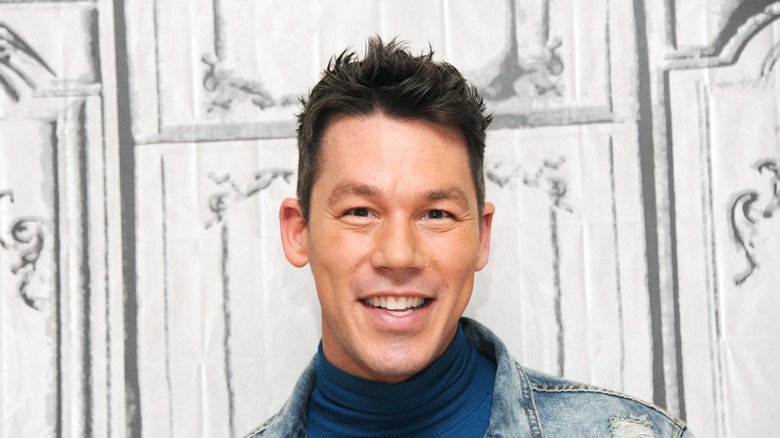 David Bromstad smiles at the camera in front of a white background