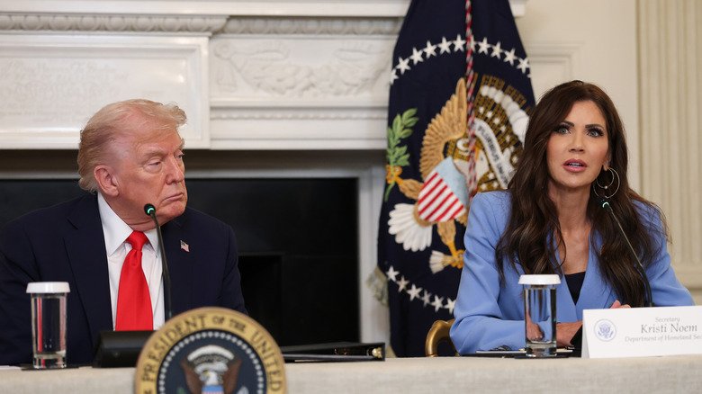 Donald Trump sitting beside Kristi Noem and looking sideways at her