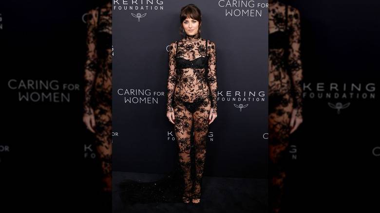 Dakota Johnson poses for a photo in a sheer, custom Gucci dress