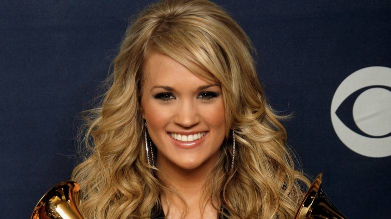 Carrie Underwood Original Lips: A Look Back Before the Big Change 139 Carrie Underwood smiling and holding Grammys.