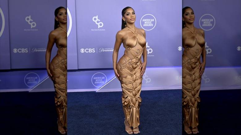 The 2026 American Music Awards Was A Fashion 137 Amaya Espinal wearing a beige dress comprised of fabric strips attached to silver rings at the 2026 AMAs.
