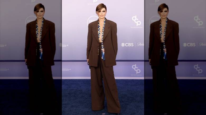 The 2026 American Music Awards Was A Fashion 138 Lisa Rinna wearing a baggy brown suit and undone polka-dot tie featuring an image of JFK at the 2026 AMAs.