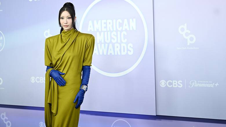 The 2026 American Music Awards Was A Fashion 140 Ejae wearing a draped green dress and blue opera-length gloves at the 2026 AMAs.