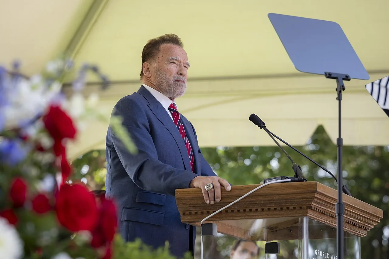Open the featured image for Arnold Schwarzenegger Net Worth 2026: How His $1.2B Fortune Was Built Arnold Schwarzenegger speaking at a naturalization ceremony at Mount Vernon in 2025
