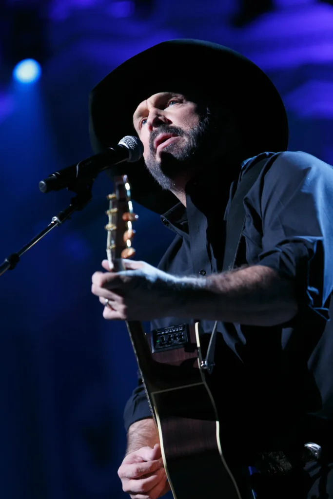 Garth Brooks performing onstage with a guitar