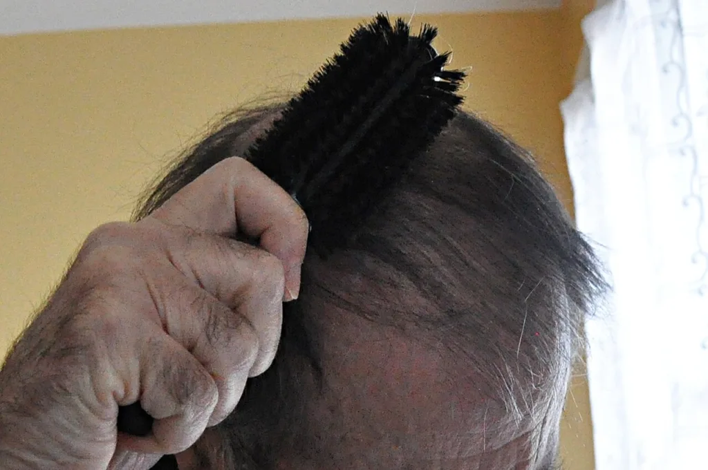A person using a hairbrush, illustrating Jessie Cave's hair-focused OnlyFans content