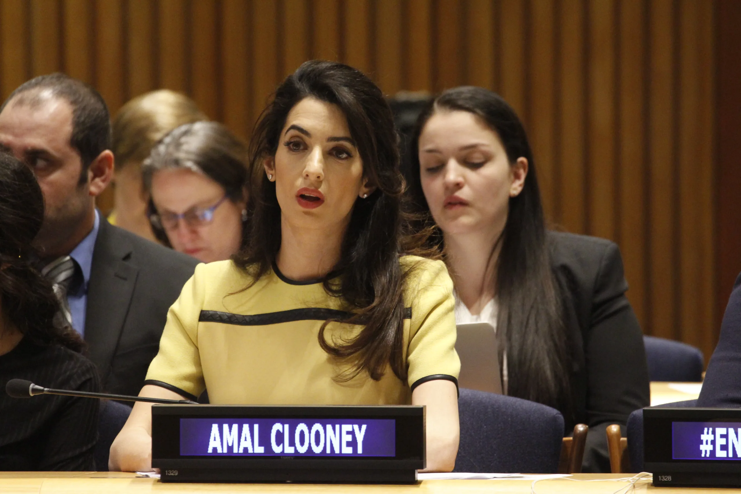 Open the featured image for Amal Clooney Venice Style: Why Her 2026 Arrival Look Works Amal Clooney speaking at a United Nations event in a tailored yellow dress