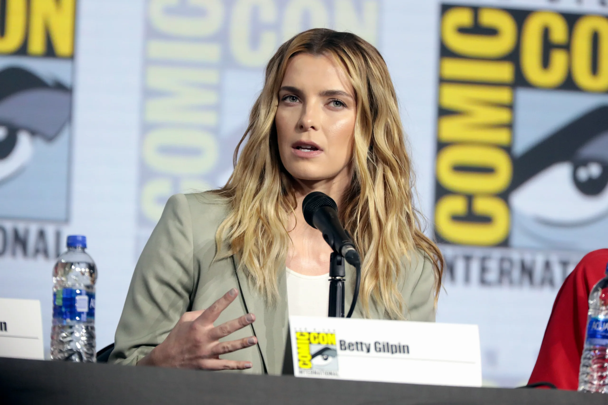 Open the featured image for Betty Gilpin Emmy Win Adds a New Chapter After GLOW Betty Gilpin speaking at San Diego Comic-Con in 2019
