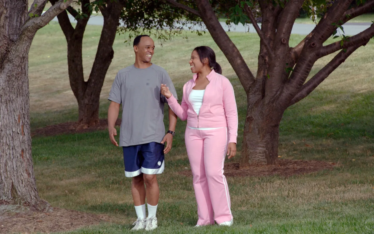 An older couple walking together in a park for regular physical activity