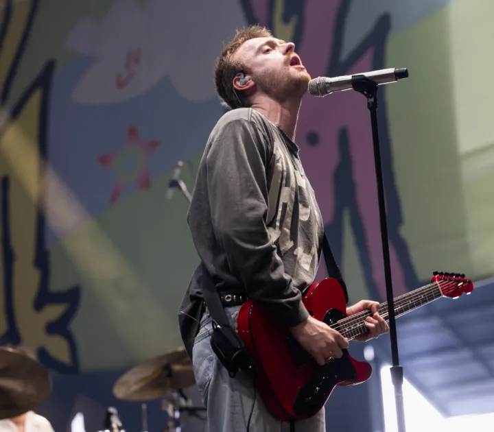 Finneas performing onstage during a live music festival appearance
