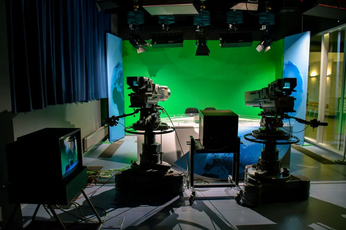 Open the featured image for Creator FAST Channels Are Moving Social Video Into Television Television studio cameras and green screen representing creator FAST channels and streaming production