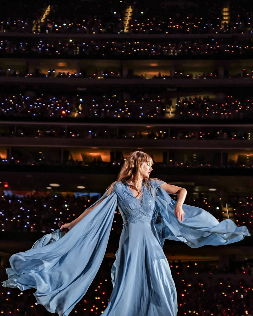 Taylor Swift performing in a blue dress during the folklore set of the Eras Tour