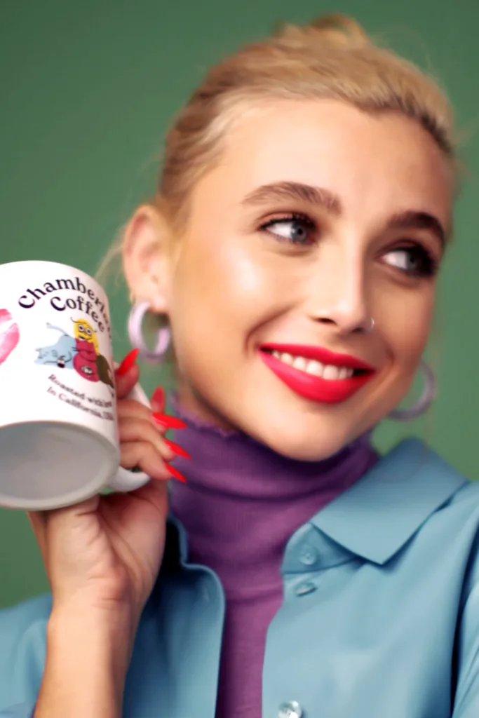 Emma Chamberlain holding a Chamberlain Coffee mug in promotional imagery