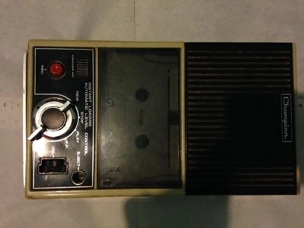 An older portable cassette recorder with playback controls and a built-in speaker