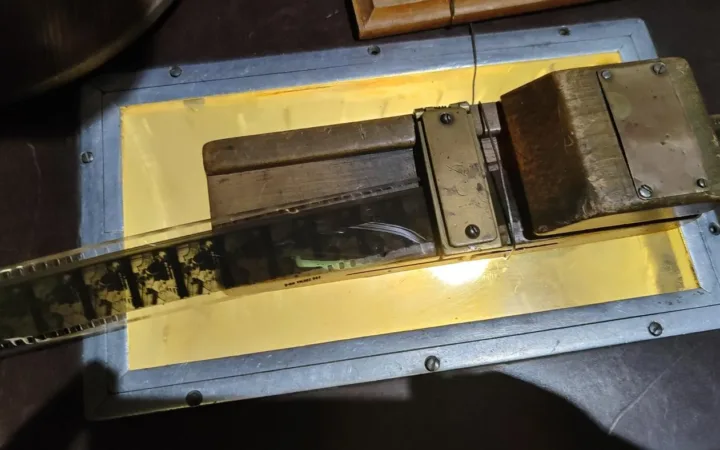 A strip of 35 mm film lies across an illuminated editing table.
