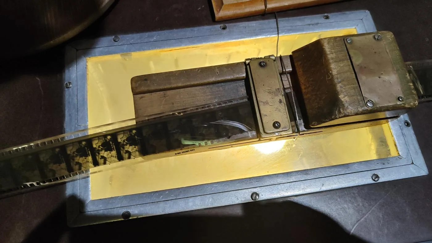 A strip of 35 mm film lies across an illuminated editing table.